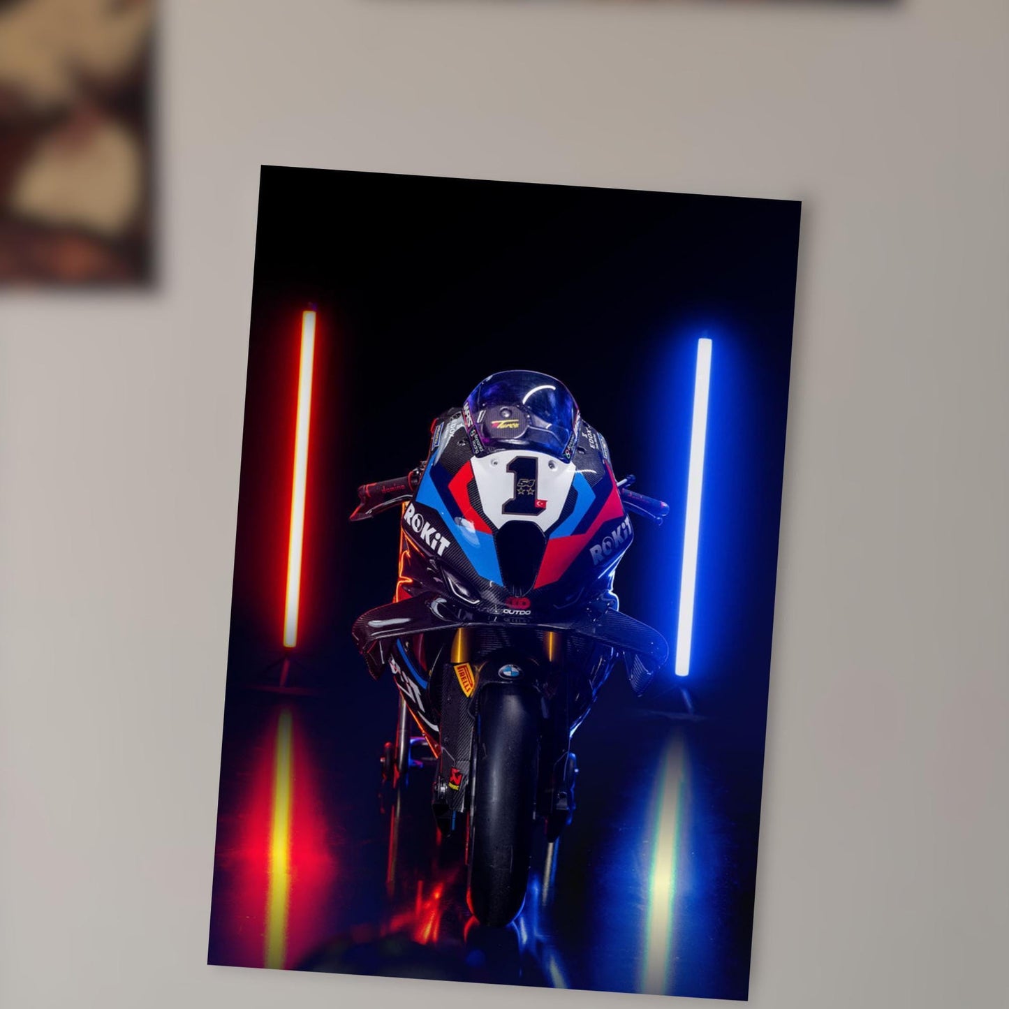 A motorcycle with a number 1 on the front is shown in a dark room, with red and blue lights illuminating the motorcycle and creating a dramatic effect.