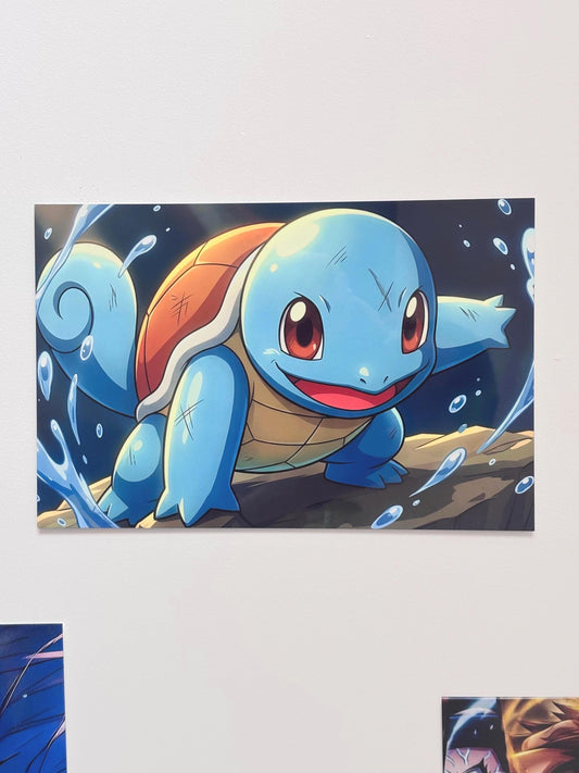Tableau métallique en aluminium brillant de format paysage représentant le Pokémon Carapuce (Squirtle) bondissant sur une vague avec le texte "SQUIRTLE" et "Gotta Catch 'Em All!", posé sur une couverture grise.