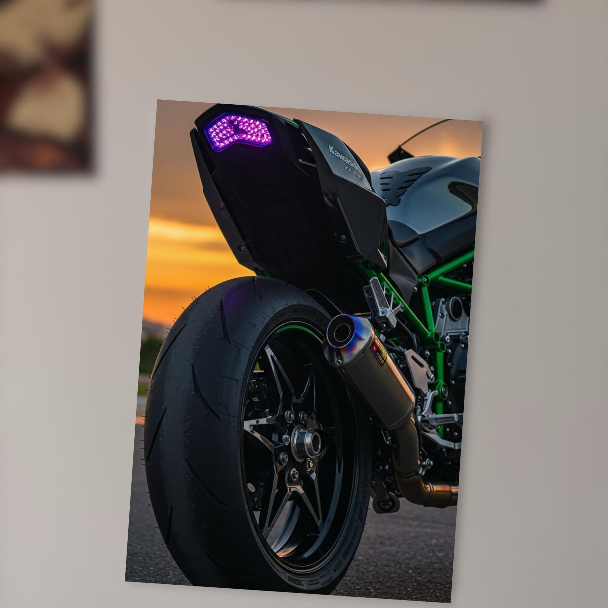 A close-up view of a motorcycle's rear tire and exhaust pipe, with a colorful back light on the motorcycle.
