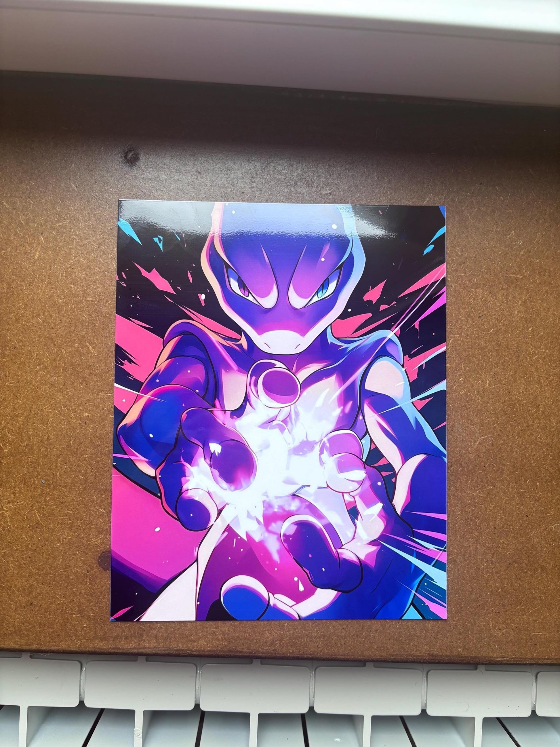 Peut inclure: Une impression d'art rectangulaire représentant une créature stylisée violette et bleue aux yeux brillants, tendant les mains vers l'avant pour générer une explosion d'énergie blanche et crépitante sur un fond rose vif et bleu foncé.